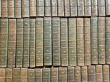 rows of old books stacked on top of each other in a room
