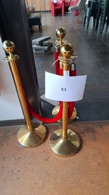 a red carpet and a gold pole with a sign on it