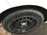 a white car with a flat tire on the side of the road