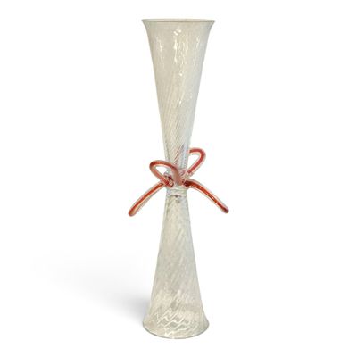a glass vase with a red ribbon tied to it