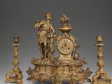 a gold clock with a statue on top of it