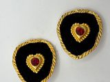 two black and gold heart shaped buttons on a white surface