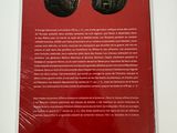 un livre rouge avec deux pièces d'argent sur la couverture