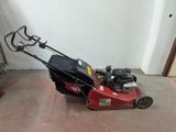 a red lawn mower that is sitting on the ground