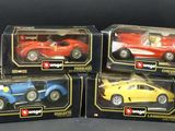 four toy cars are in a box on a black surface