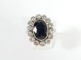 a close up of a ring with a blue stone surrounded by white diamonds
