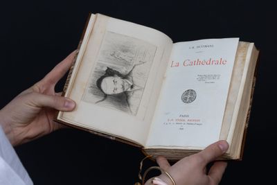 une personne tenant un livre ouvert sur lequel figure un dessin