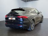 the rear of a black car is parked in a garage