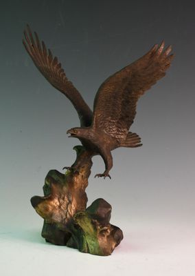 une statue représentant un aigle perché sur une souche d'arbre