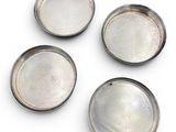 four silver metal trays on a white surface with a white background
