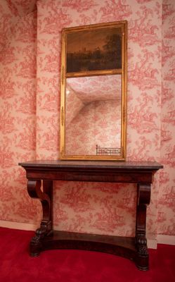 a mirror on a table in a room with a red carpet