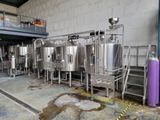 many stainless steel tanks lined up inside of a building
