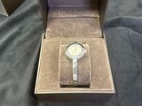 an open box with a watch inside of it on a bed