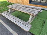 a wooden picnic table sitting in front of a building
