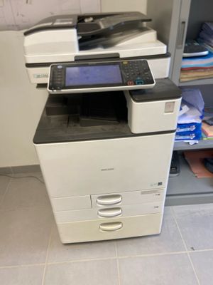 a printer that is sitting on the floor in front of a cabinet