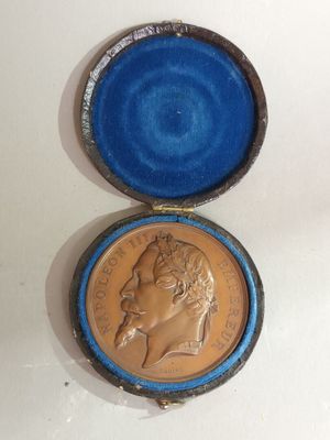 an old coin in a blue box with a gold crown on it