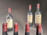 several bottles of wine are lined up in a row on a table
