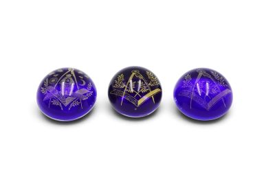 three purple marbles with gold designs on them on a white surface