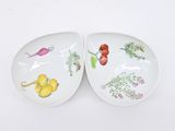 two plates with different types of food on them on a white surface