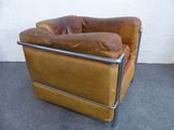 a brown leather chair with a metal frame on the floor