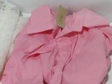 a pile of pink and white towels on a white shelf
