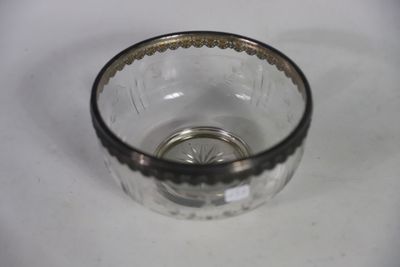 a small glass bowl with a silver rim on a table