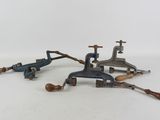 Plusieurs types d'outils de plomberie sont posés sur une surface blanche.