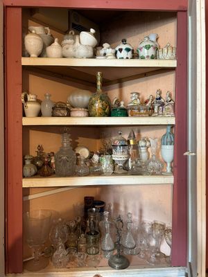 a cabinet with many glass items on the shelves