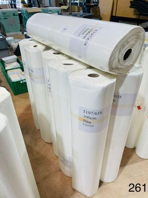 several rolls of paper are stacked on top of each other in a warehouse