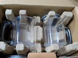 a cardboard box filled with a couple of cups and a bottle