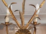 a gold colored chandelier with four candles on it
