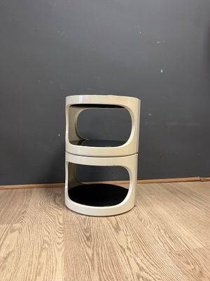 a white trash can sitting on the floor next to a gray wall