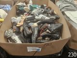 plusieurs paires de chaussures dans une boîte en carton posée sur le sol