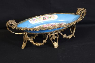 a blue and gold plate on a stand on a black background