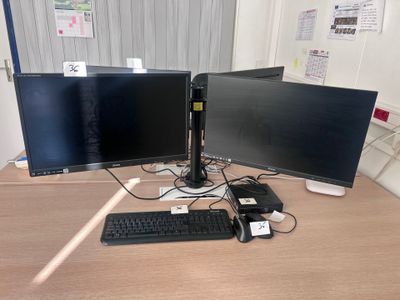 two computer monitors and a keyboard on a desk