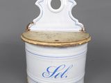 an old white and blue tin with a wooden lid on a gray surface