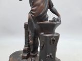 bronze statue of a boy with a baseball bat and a bucket