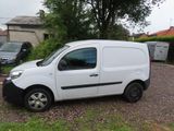 a white van parked in a parking lot next to a house