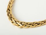 a close up of a gold necklace on a white surface