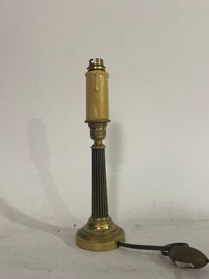 an antique brass table lamp on a white background with a black cord