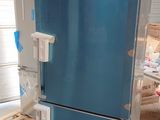 a blue refrigerator sitting on a pallet in a warehouse