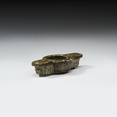 une ancienne figurine en bronze représentant un bateau sur un fond blanc