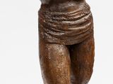 une statue représentant un homme portant un panier sur la tête