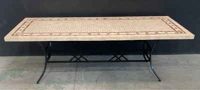 un gros plan d'une table au plateau en carrelage posée sur un sol carrelé