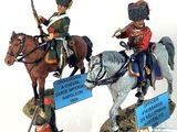 three figurines of soldiers riding horses on display