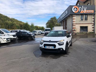 La voiture blanche est garée devant un immeuble devant lequel sont garées d'autres voitures.