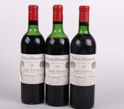 trois bouteilles de vin rouge posées l'une à côté de l'autre sur une surface blanche