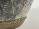 a close up of a large metal bowl on a white surface