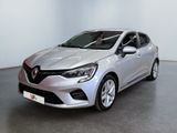 Une voiture argentée est garée dans une pièce aux murs blancs
