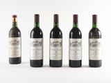 four bottles of wine are lined up on a white surface